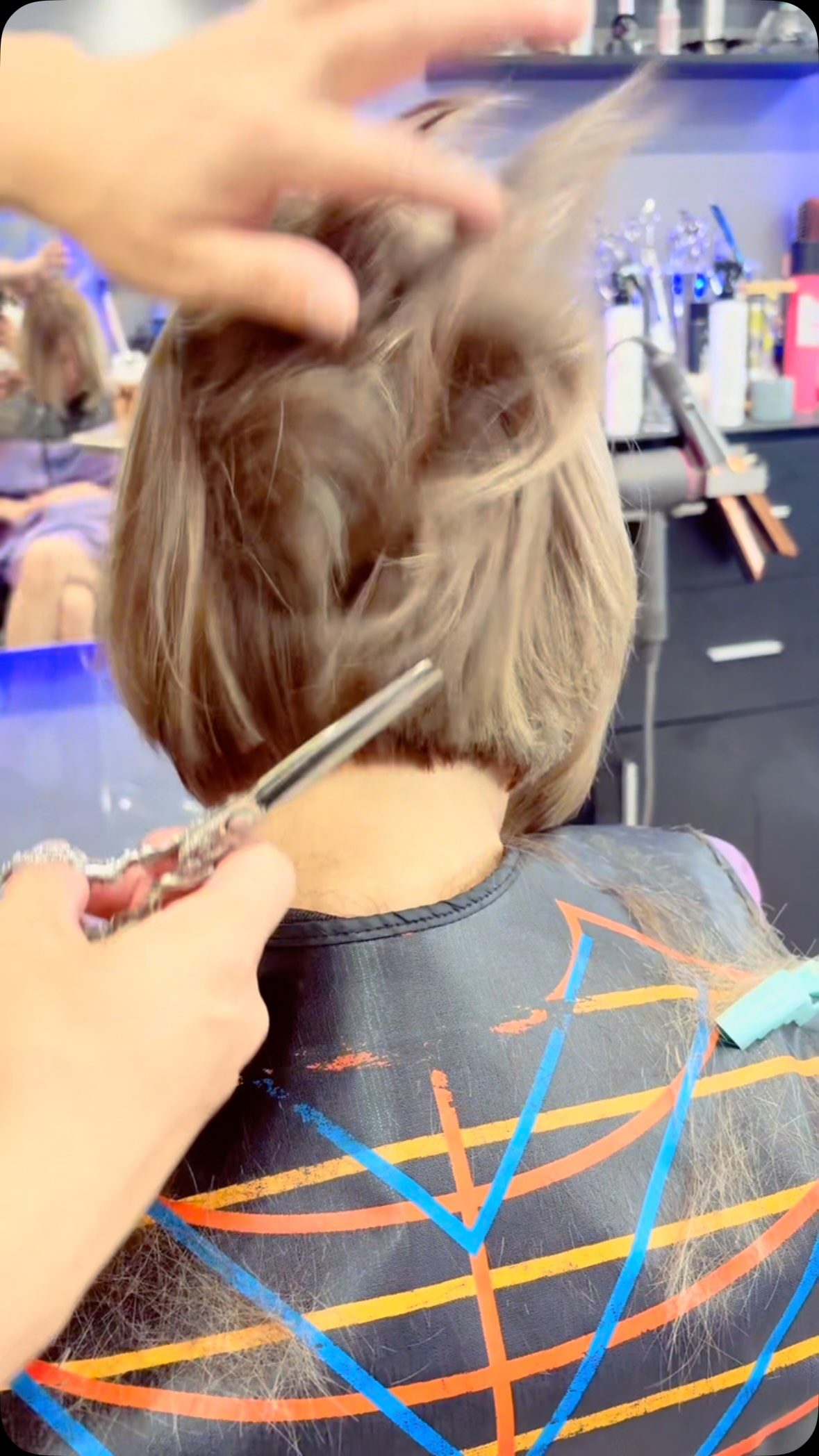 A client receiving a haircut in the salon at Phong Beauty Salon